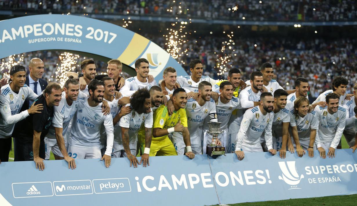 Cristiano Ronaldo (kiri) berfoto bersama timnya saat meraih trofi Piala Super Spanyol 2017 bersama rekannya di Santiago Bernabeu stadium, Madrid, (16/8/2017). Real menang agregat 5-1. (AP/Francisco Seco)