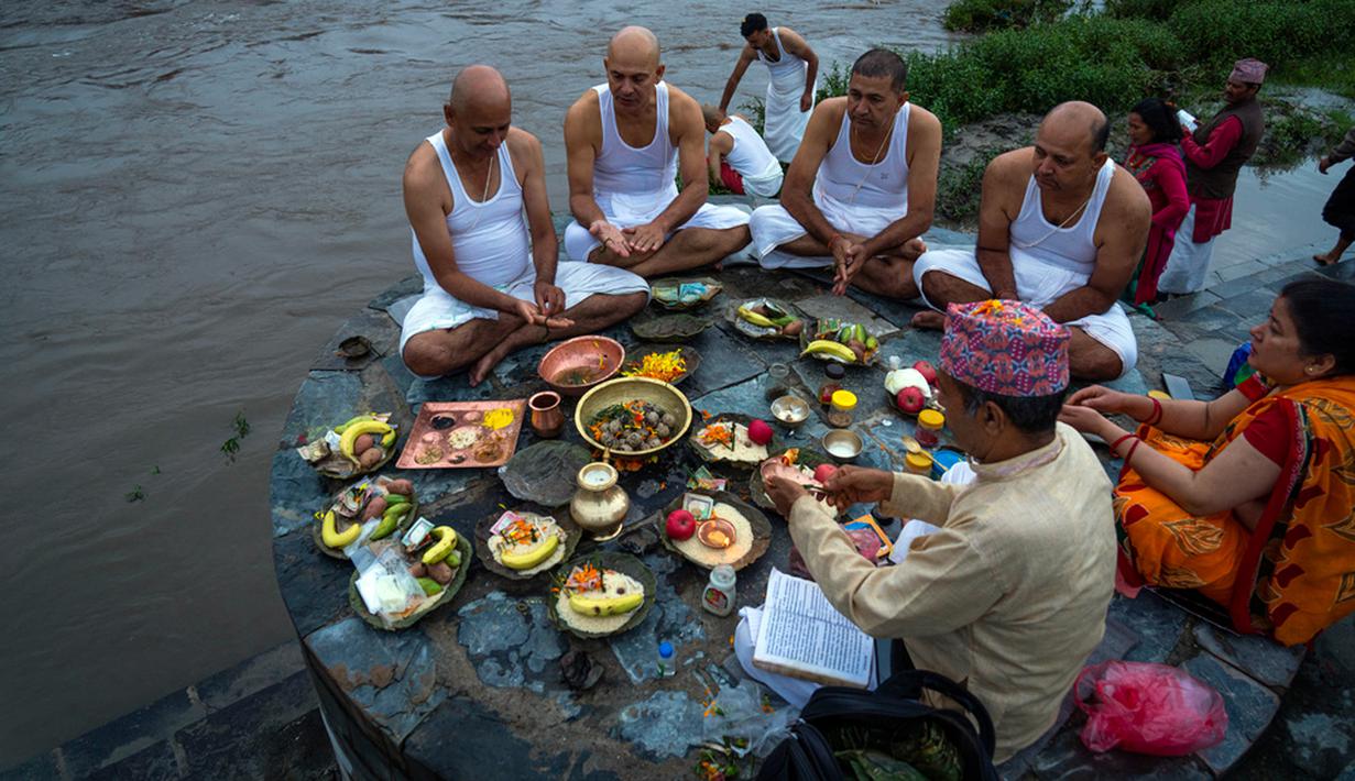 Selama perayaan Festival Kuse Aunsi, banyak orang berziarah ke Kuil Gokarneshwor, yang terletak di bagian timur laut Kathmandu. Di sana, mereka mandi serta memberikan persembahan. (AP Photo/Niranjan Shrestha)