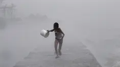 Seorang anak laki-laki berlari di tengah hujan lebat saat badai topan Linfa disertai gelombang laut menghantam Teluk Manila, Filipina, Senin (6/7/2015). Akibat badai aktivitas penerbangan, pelabuhan dan sekolah-sekolah ditutup. (REUTERS/Romeo Ranoco)