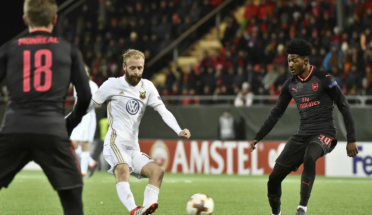 Pemain Ostersund, Curtis Edwards (tengah) saat diadang pemain Arsenal, Ainsley Maitland-Niles pada babak 32 besar Liga Europa di Jamtkraft Arena, Ostersund, Swedia (15/2/2018). Arsenal menang 3-0. (Robert Henriksson/TT News Agency via AP)