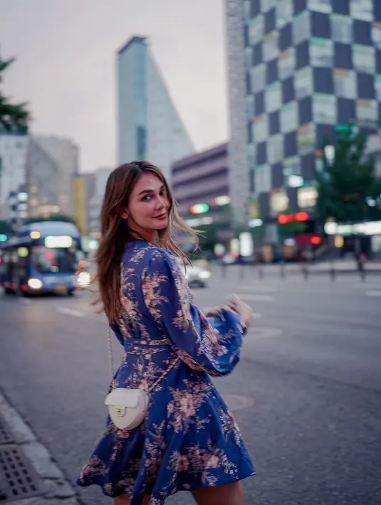 Gaya elegan Luna Maya saat berlibur ke Seoul, Korea Selatan. Ia mengenakan mini dress lengan panjang berwarna biru. Dress ini semakin cantik karena dihiasi motif floral. Luna juga menambahkan mini sling bag berwarna putih. [Foto: Instagram/lunamaya]