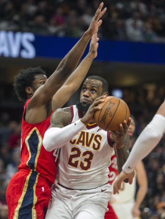 Pebasket Cleveland Cavaliers, LeBron James, berusaha melewati pebasket New Orleans Pelicans,Solomon Hill, pada laga NBA di Quicken Loans Arena, Sabtu (31/3/2018). Cavaliers menang 107-102 atas Pelicans. (AP/Phil Long)