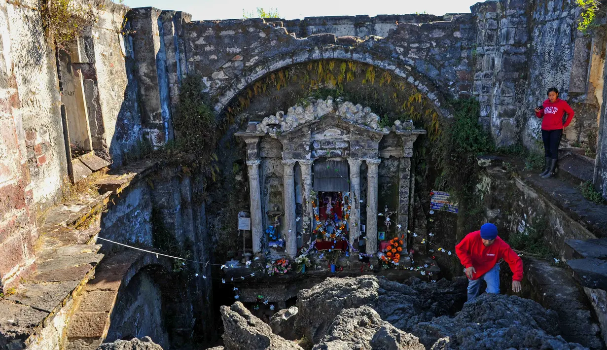 Wisatawan saat mengunjungi gereja San Juan Parangaricutiru di Angahuan, Meksiko, 17 Januari 2016. Gereja ini disebut sebagai keajaiban Tuhan karena luput dari sapuan lava gunung berapi pada  20 februari 1943 silam. (AFP PHOTO / Mario Vazquez)