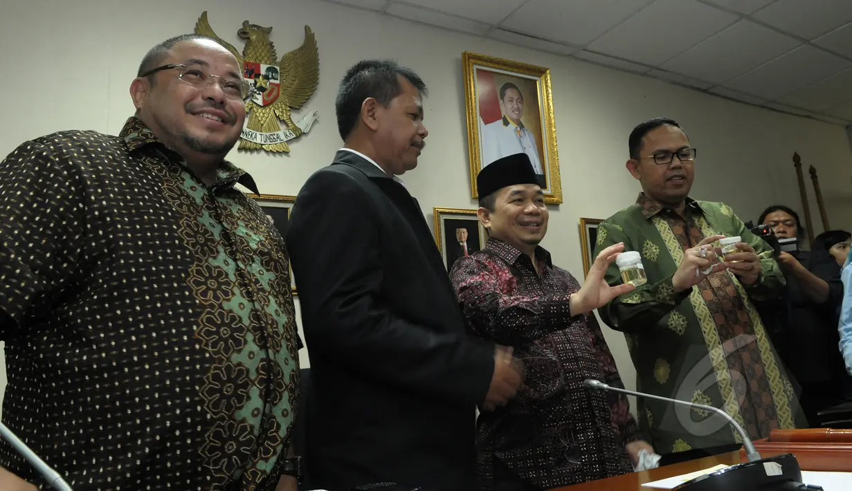 Ketua F-PKS Jazuli Juwaini (kedua kanan) bersama Kasubdit Peran Serta Masyarakat BNN Dik Dik Kusnadi (kedua kiri) menunjukan urine usai tes di ruang Fraksi PKS, Kompleks Parlemen Senayan, Jakarta, Kamis (26/03/2015). (Liputan6.com/Andrian M Tunay)