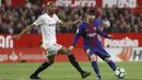 Pemain Barcelona, Lionel Messi (kanan) mengecoh pemain Sevilla, N'zonzi pada laga La Liga Santander di Sanchez Pizjuan stadium, (31/3/2018). Barcelona bermain imbang 2-2 dengan Sevilla. (AP/Miguel Morenatti)