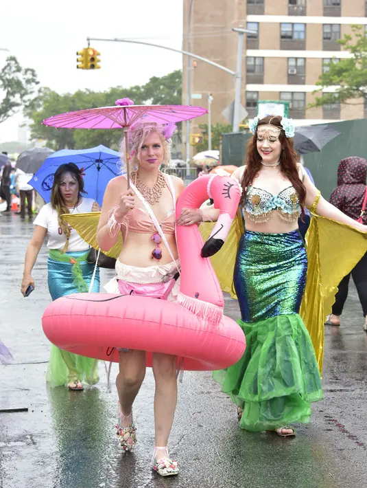 Sejumlah pengunjung mengenakan kostum putri duyung mengikuti Parade Mermaid 2017 di Coney Island, New York City (17/6). (Eugene Gologursky/Getty Images for Stellar Productions/AFP)
