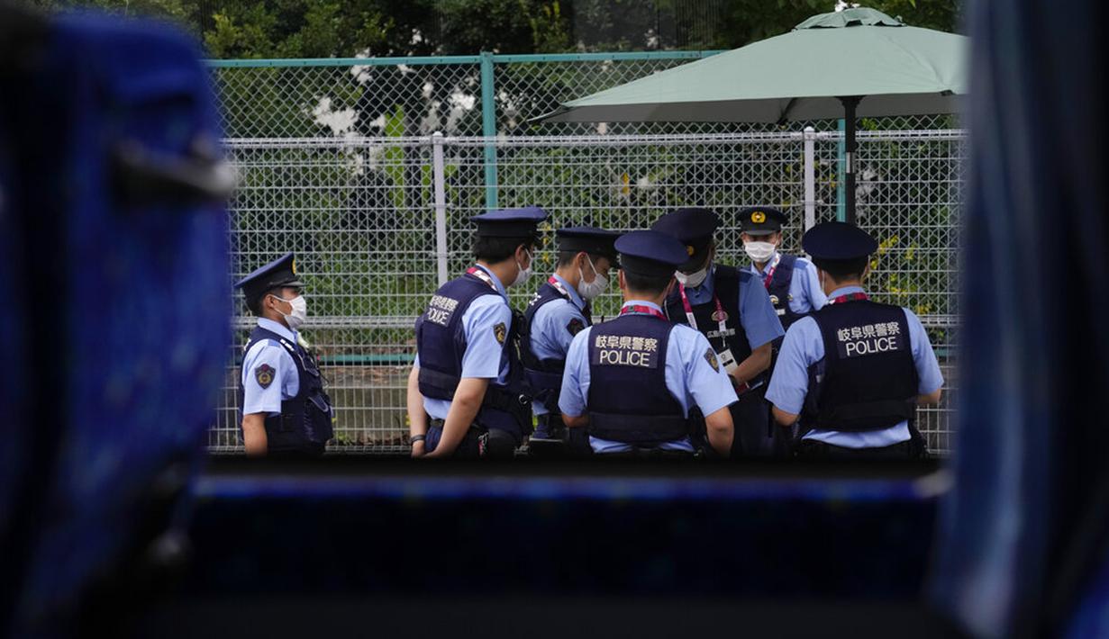 Polisi berkumpul dekat pusat pers utama Olimpiade 2020 di Tokyo, Jepang, Rabu (14/7/2021). Keadaan darurat akan berlaku sepanjang Olimpiade yang dibuka pada 23 Juli. (AP Photo/Jae C. Hong)