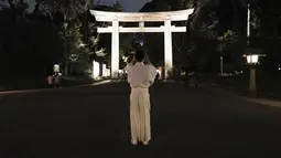 Pendeta kuil mengambil foto sebuah torii, atau gerbang kuil di Kuil Meiji Jingu Shinto untuk menandai peringatan 100 tahun berdirinya di Tokyo, Jumat (30/10/2020). Meiji Jingu, dibangun untuk memberi penghormatan kepada Kaisar Meiji dan Permaisuri Shoken pada tahun 1920 (AP Photo/Eugene Hoshiko)