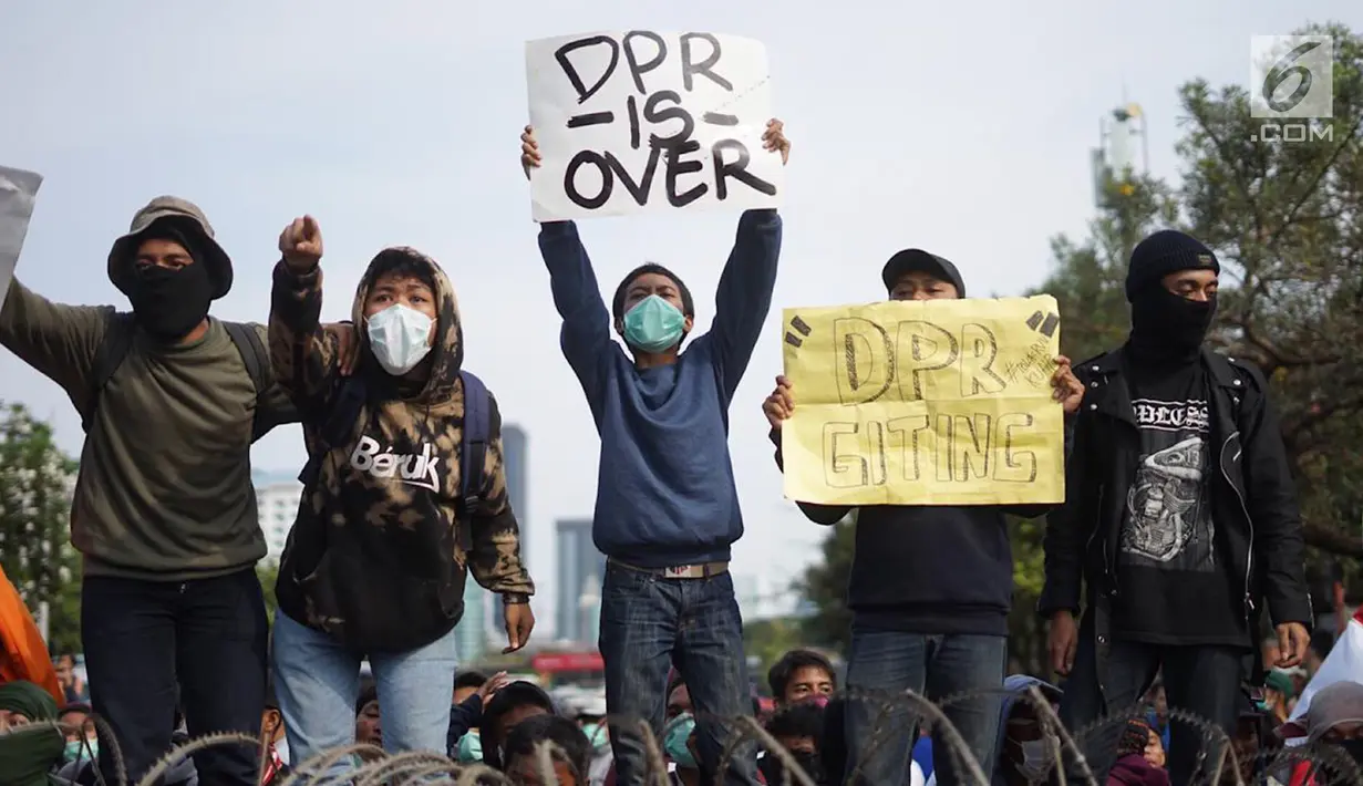 Massa aksi yang tergabung dari elemen mahasiswa, buruh, dan pelajar membawa spanduk dalam unjuk rasa di depan Gedung DPR RI, Jakarta, Senin (30/9/2019). Aksi unjuk rasa tersebut menyikapi penolakan terhadap UU KPK dan sejumlah RUU yang dinilai bermasalah. (Liputan6.com/Immanuel Antonius)