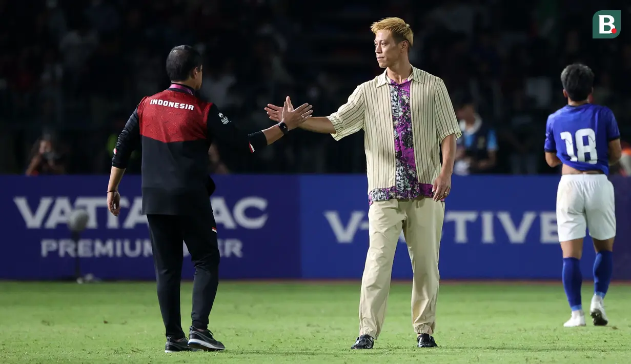 Pelatih Timnas Kamboja U-22, Keisuke Honda berjabat tangan dengan pelatih Timnas Indonesia, Indra Sjafri setelah laga Grup A Sepak Bola SEA Games 2023 di Olympic National Stadium, Phnom Penh, Kamboja, Rabu (10/5/2023) malam WIB. Honda terkenal dengan gaya berpakaian unik saat mendampingi Kamboja pada perhelatan akbar olahraga di Asia Tenggara tersebut. (Bola.com/Abdul Aziz)