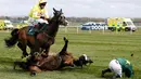 Kuda bernama Curious Carlos terjatuh saat ditunggai oleh Sean Bowen pada pacuan kuda festival nasional Crabbie Grand Liverpool, Inggris, Kamis (7/4/2016). Sean Bowen sempat terinjak oleh kuda tunggannya tersebut. (Reuters / Andrew Boyers)
