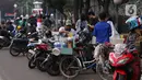 Pedangang membuat minuman untuk massa aksi saat demo penolakan omnibus law di kawasan Patung Kuda, Jakarta, Selasa (20/10/2020). Para pedagang kaki lima memanfaatkan moment aksi massa untuk mencari ke untungan meskipun sangat membahayakan bagi keselamatan mereka. (Liputan6.com/Angga Yuniar)