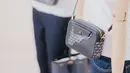 Sudut-sudut tas, dengan detail mewah berbahan kulit sapi berurat, terinspirasi oleh penguatan sudut pada tas berburu, sementara piping khas seragam militer mengelilingi bagian dasar.