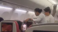 Seorang ibu menolak anaknya dipakaikan sabuk pengaman jelang pesawat Batik Air lepas landas. (dok. tangkapan layar Instagram Story @fegiegie)