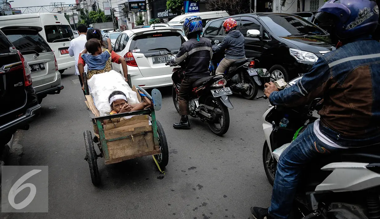 Tatapan seorang bocah yang dibawa ibunya dengan gerobak melintasi jalan Wahid Hasyim, Jakarta untuk mencari barang bekas, Kamis (6/10). Penduduk miskin Jakarta meningkat menjadi 384.300 orang atau 3,75% dari total penduduk. (Liputan6.com/Faizal Fanani)