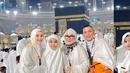 Potret Ayu dan keluarga di depan Ka'bah mencerminkan kebahagiaan dan kekhusyukan mereka. Mengenakan ihram putih, mereka tampak menikmati momen sakral di Masjidil Haram. Ka'bah yang megah di malam hari menambah kedamaian suasana.  (Liputan6.com/IG/@ayutingting92)