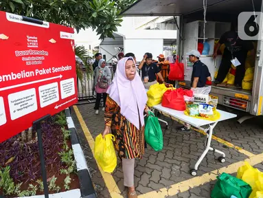 Warga usai membeli paket sembako di Bazar Ramadan Sembako Murah LRT Jakarta di Jakarta Utara, Senin (25/3/2024). (Liputan6.com/Angga Yuniar)