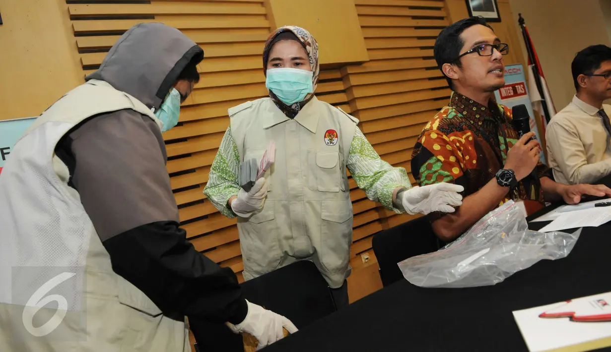 Petugas bersiap menunjukkan barang bukti uang saat konferensi pers di Gedung KPK, Jakarta, Kamis (15/12). Terkait OTT yang menjerat Deputi Bakamla, Eko Susilo Hadi, KPK menyita uang Rp 2 miliar dalam pencahan dolar Singapura. (Liputan6.com/Helmi Afandi)