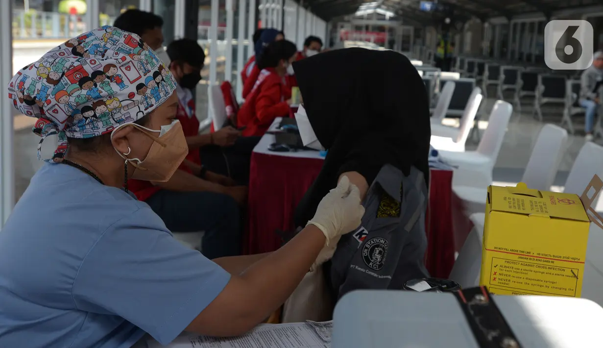 Tenaga kesehatan menyuntikkan cairan vaksin ke penumpang KRL Commterline serta  masyarakat umum  di Stasiun Kota, Jakarta, Rabu (28/7/2021). Vaksinasi disediakan 300 dosis bagi penumpang dan masyarakat umum guna menekan penyebaran Covid-19.  (merdeka.comm/Imam Buhori)