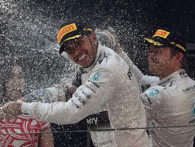 Nico Rosberg membalas menyemprotkan sampanye ke muka Lewis Hamilton