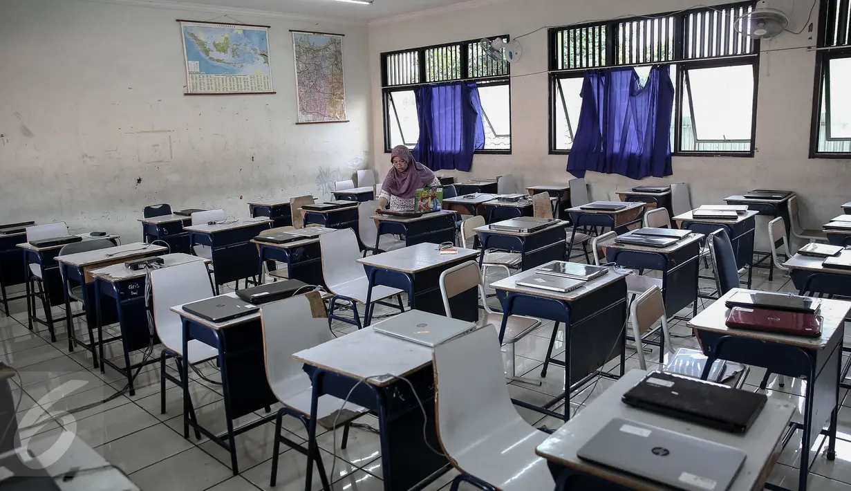  Petugas menyiapkan komputer/laptop  untuk ujian nasional berbasis komputer (computer based test/CBT) di SMP N 1, Jakarta, (7/5/2016). Sebanyak 280 siswa-siswi SMP Negeri 1 Jakarta mengikuti ujian nasional berbasis komputer. (Liputan6.com/Faizal Fanani)