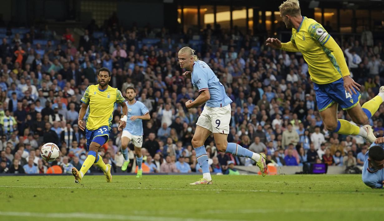 Erling Haaland kembali mencetak gol pada menit ke-23. Kali ini giliran kaki kanannya yang menjebol gawang Nottingham Forest usai mendapatkan bola liar di depan gawang Dean Henderson yang didahului oleh aksi Phil Foden. (AP/Dave Thompson)