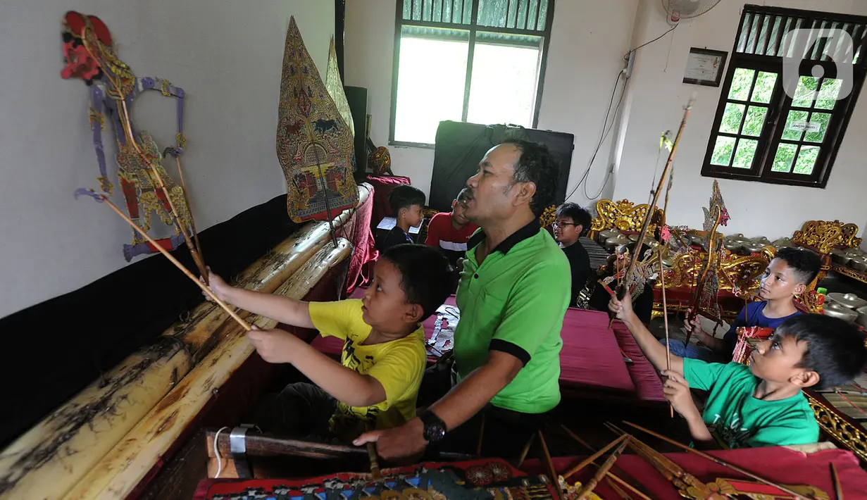 Anak-anak berlatih mendalang wayang kulit di Sanggar Nirmalasari, Cinere, Depok, Jawa Barat, Minggu (9/2/2020). Sumber dana Sanggar Nirmalasari hanya diperoleh dari para siswa dan kantong pribadi pengasuh. (merdeka.com/Arie Basuki)