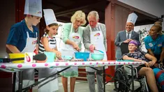 Pangeran Charles bersama sang istri Camilla Parker membuat kue lamington bersama anak-anak di Brisbane, Australia, Rabu (4/4). Kegiatan itu dilakukan dalam kunjungannya ke Rumah Sakit Anak Lady Cilento. (Patrick HAMILTON/POOL/AFP)