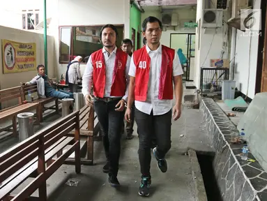 Musikus Marcello Tahitoe atau Ello bersama rekannya Diego berjalan usai menjalani sidang putusan di Pengadilan Negeri Jakarta Selatan, Selasa (16/1). Majelis hakim memvonis Ello dan Diego selama 9 bulan rehabilitasi. (Liputan6.com/Herman Zakharia)