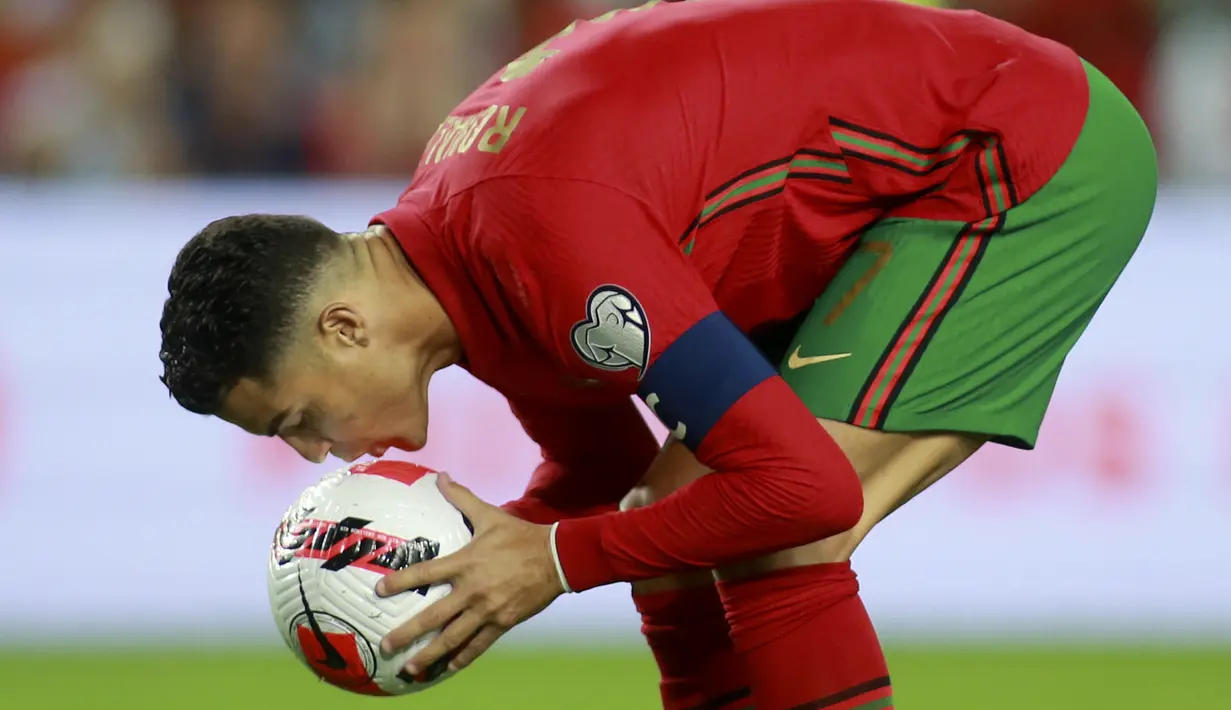 Penyerang Portugal Cristiano Ronaldo mencium bola sebelum melakukan tendangan penalti ke gawang Luksemburg pada lanjutan Kualifikasi Piala Dunia 2022 di Stadion Do Algarve, Rabu (13/10/2021) dini hari WIB. Hat-trick Ronaldo membuat Portugal menang 5-0 atas Luksemburg. (AP Photo/Joao Matos)