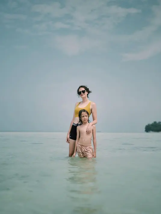 Berenang di pantai bersama putranya, Sabai pamer body goals idaman. Mengenakan sport bra berwarna kuning mustard, dipadu legging hitam pendek, Sabai tampil slay mengenakan sunglasses. Foto: Instagram.