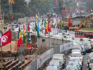 Deretan bendera negara peserta Konferensi Asia Afrika ke-60 terpasang di dinding proyek MRT kawasan Bundaran HI, Jakarta, Selasa (14/4/2015). Persiapan ini dilakukan di sepanjang jalur yang dilalui peserta negara KAA ke-60.  (Liputan6.com/Faizal Fanani)