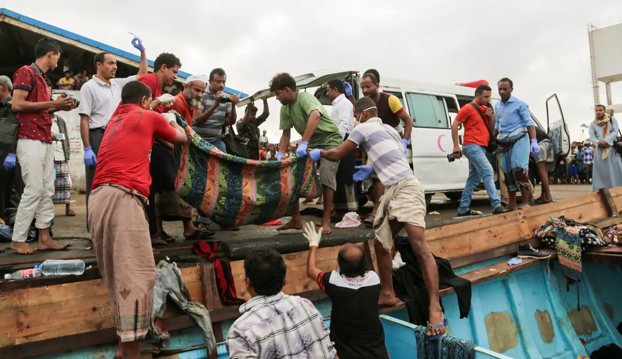 Warga mengevakuasi jenazah pengungsi Somalia yang tewas akibat serangan sebuah helikopter di lepas pantai Yaman, Jumat (17/3). Dikabarkan kapal pengungsi Somalia diserang oleh helikopter jenis Apache. (AFP Photo/STR)