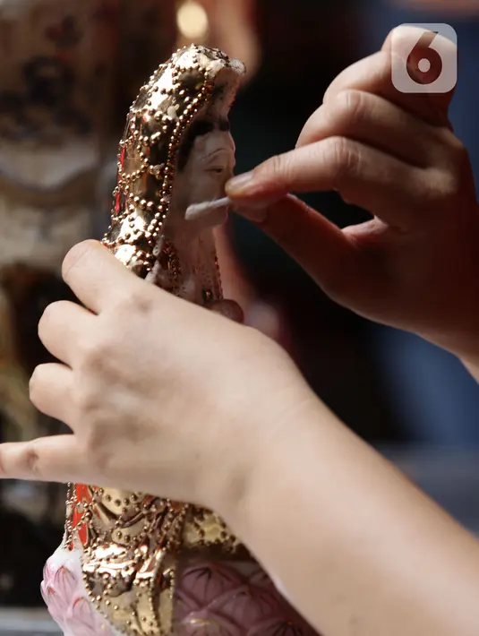 Warga keturunan Tionghoa melaksanakan tradisi membersihkan patung dewa-dewi atau rupang di Vihara Dhanagun, Kota Bogor, Rabu (27/1/2022). Proses pembersihan rupang ini biasa dilakukan sebagai tanda penyucian kembali sebelum merayakan dan memasuki Tahun Baru Imlek. (Liputan6.com/Helmi Fithriansyah)
