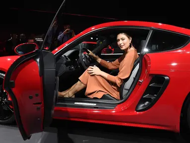 Petenis cantik asal Rusia, Maria Sharapova berpose di kursi pengemudi Porsche 718 Cayman GTS selama pameran mobil AutoMobility LA di Los Angeles Convention, California (29/11). Sharapova tampil cantik dengan gaun berwarna coklat. (AFP/Kevork Djansezian)