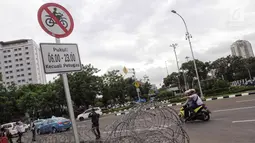 Plang pemberitahuan larangan sepeda motor melintas yang terpampang di jalan Medan Merdeka Barat, Jakarta, Selasa (7/11). Anies meminta ada perubahan agar motor bisa difasilitasi di Jalan MH Thamrin. (Liputan6.com/Faizal Fanani)