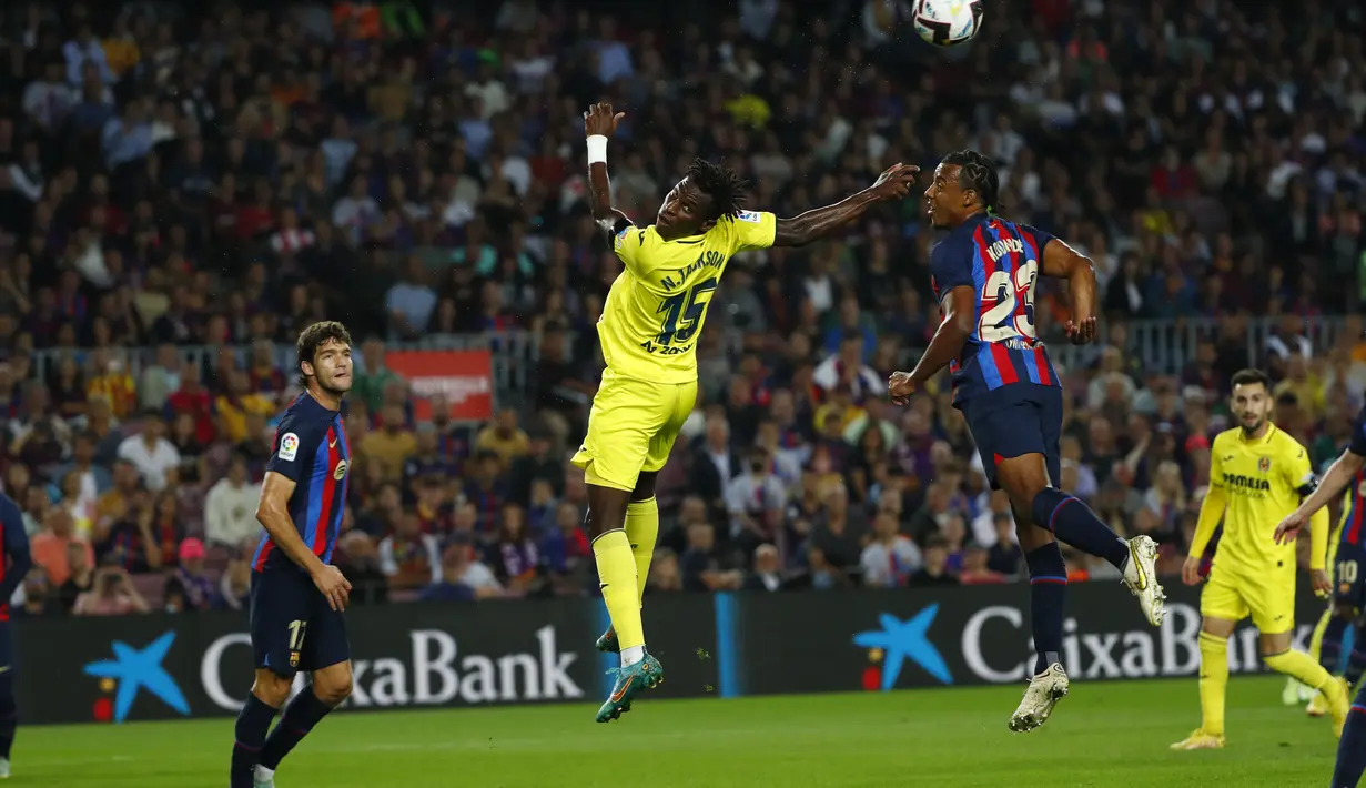 Penyerang Villareal, Nicolas Jackson berusaha menyundul bola dari kawalan bek Barcelona, Jules Kounde selama pertandingan lanjutan La Liga Spanyol di stadion Camp Nou di Barcelona, Spanyol, Jumat (21/10/2022). Berkat kemenangan ini, Barcelona menempati posisi kedua dengan 25 poin dari 10 laga, tertinggal tiga angka dari Madrid yang ada di puncak. (AP Photo/Joan Monfort)