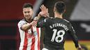 Gelandang Manchester United, Bruno Fernandes (kanan), terlibar pertikaian dengan bek Sheffield United, George Baldock, dalam laga lanjutan Liga Inggris pekan ke-13 di Bramall Lane, Sheffield, Kamis (17/12/2020). Manchester United menang 3-2 atas Sheffield United. (AFP/Peter Powell/Pool)