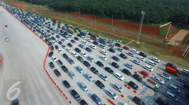 Pantauan udara arus balik libur panjang di tol Cikopo, Jawa Barat, Minggu (27/3). Kendaraan mengantri hingga 1 km untuk memasuki gerbang tol. (Liputan6.com/Muhammad Husni)