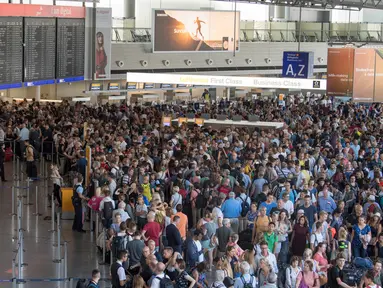Para calon penumpang menunggu kejelasan penerbangan mereka di aula terminal 1 Bandara Frankfurt, Jerman, Selasa (7/8). Sejumlah penerbangan harus dibatalkan setelah seorang yang tidak dikenal menyusup melewati pos pemeriksaan. (Boris Roessler/dpa via AP)