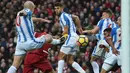 Pemain Liverpool, Roberto Firmino (2kiri) mencetak gol saat diadang para pemain Huddersfield Townt pada lanjutan Premier League di Stadion Anfield, Liverpool, (28/10/2017). Liverpool menang 3-0. (AFP/Paul Ellis)