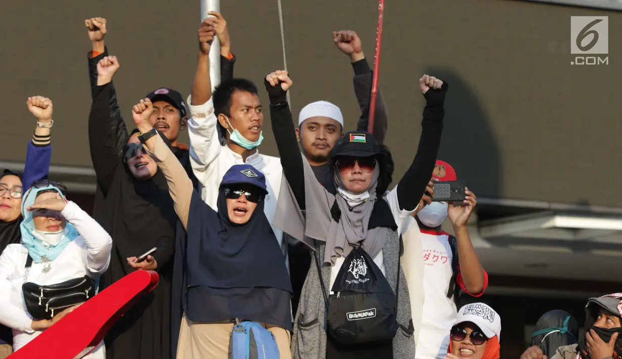 Peserta aksi massa Gerakan Nasional Kedaulatan Rakyat berdiri di pagar gedung pertokoan Sarinah saat melakukan unjuk rasa di sekitar Gedung Bawaslu, Jakarta, Rabu (22/5). Dalam aksinya, mereka meminta Bawaslu memeriksa kembali hasil Pemilu 2019. (Liputan6.com/Helmi Fithriansyah)