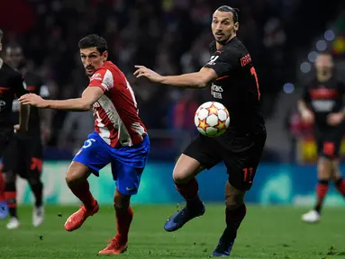 Bek Atletico Madrid Stefan Savic (kiri) dan penyerang AC Milan Zlatan Ibrahimovic berlari mengejar bola pada laga kelima Grup B Liga Champions 2021/2022 di Stadion Wanda Metropolitano, Kamis (25/11/2021) dini hari WIB. AC Milan menaklukkan tuan rumah Atletico Madrid 1-0. (OSCAR DEL POZO / AFP)