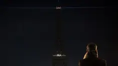 Seorang pria mengambil gambar lampu Menara Eiffel yang dipadamkan sementara di Paris, Rabu (14/12). Lampu Menara Eiffel dimatikan untuk menunjukkan dukungan bagi warga Aleppo di Suriah. (AFP PHOTO/PHILIPPE LOPEZ)