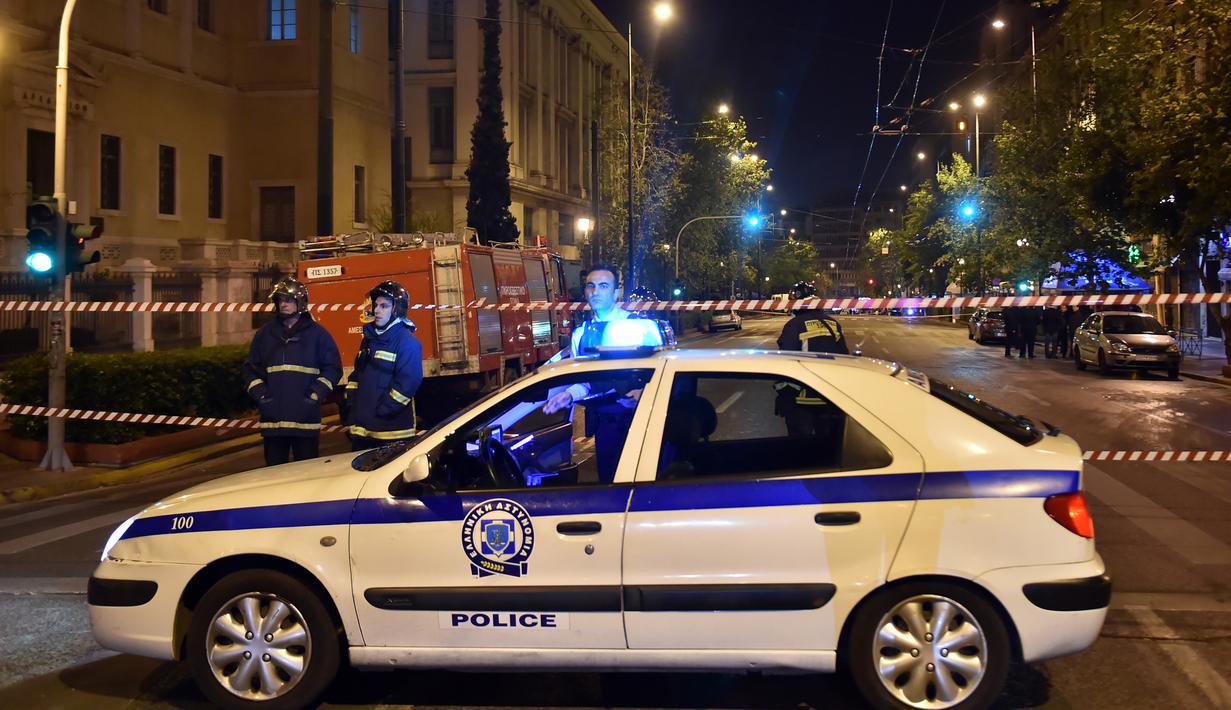 Polisi mengamankan lokasi ledakan bom yang menghantam sebuah kantor bank Eurobank di pusat kota Athena, Yunani, Rabu (19/4). Berdasarkan laporan, perangkat peledak itu ditempatkan di sebuah tas yang diletakan dekat pintu masuk bank (LOUISA GOULIAMAKI/AFP)