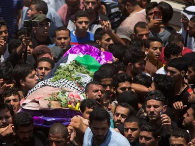 Ribuan pelayat membawa jasad perawat Palestina, Razan Najjar saat pemakamannya di Kota Khan Younis, Jalur Gaza Selatan, Sabtu (2/6). Gadis 21 tahun tersebut terbunuh oleh tembakan Israel pada Jumat, 1 Juni 2018. (AP Photo/Khalil Hamra)