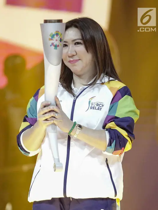 Mantan atlet bulutangkis Susi Susanti, memegang obor untuk Asian Games 2018 saat peluncuran Torch Asian Games dalam Konser 100 Hari Menuju Asian Games 2018 di Studio 6 Emtek, Jakarta, Kamis (10/5). (Liputan6.com/Faizal Fanani)