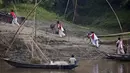 Siswa sekolah mendorong sepeda mereka ke atas bukit setelah menyeberangi sungai Brahmaputra di atas kapal di desa Kasoshila di pinggiran Gauhati, India (21/10/2019).  (AP Photo/Anupam Nath)