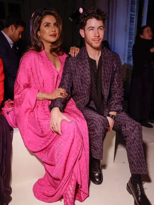 <p>Priyanka Chopra (kiri) dan Nick Jonas menghadiri koleksi siap pakai Valentino Fall/Winter 2023-2024 yang dipresentasikan di Paris Fashion Week, Paris, Prancis, 5 Maret 2023. Jonas mengenakan setelan kotak-kotak abu-abu di atas atasan hitam dan sepatu bot hitam. (Vianney Le Caer/Invision/AP)</p>