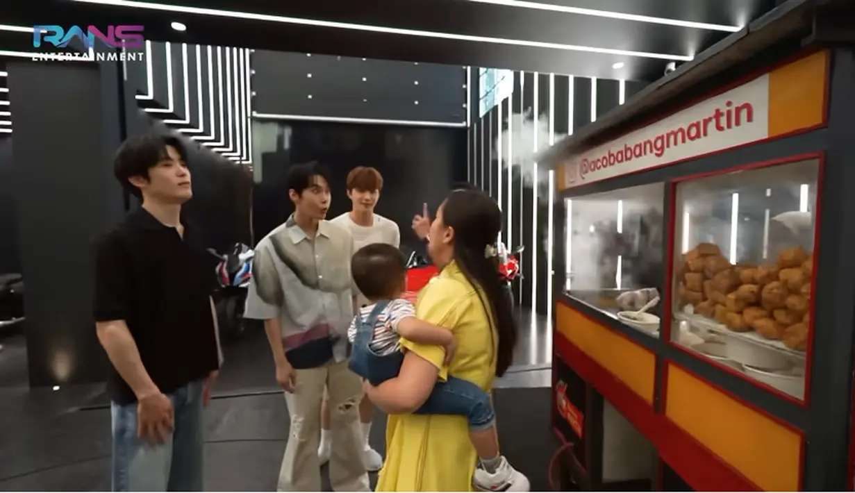 Setelah melihat-lihat, Raffi mengajak kulineran para member NCT. Tampak di garasi rumah barunya terdapat beberapa gerobak makanan. Raffi dan Gigi mengenalkan nama-nama makanan yang berjejer di garasi mewahnya. [Youtube/Rans Entertainment]